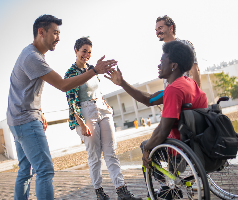 Four people with varying abilities, two of them are shaking hands